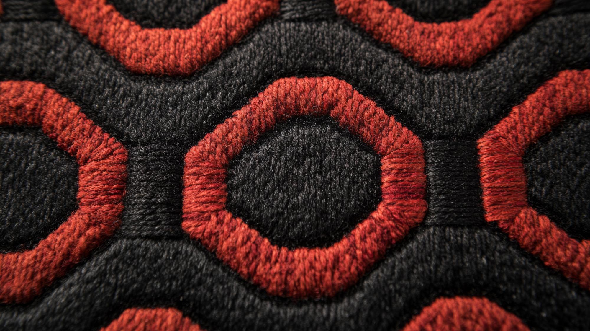 Close-up of embroidered geometric patch on dark fabric